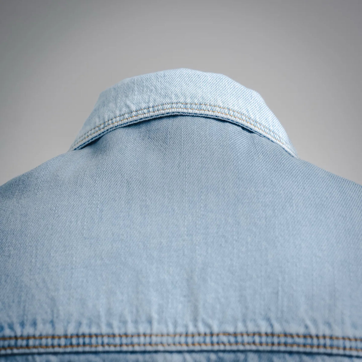 Light blue denim shirt back collar with visible seam and woven texture
