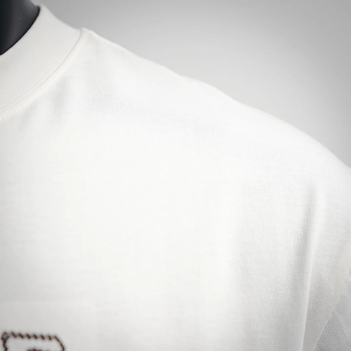 White short-sleeve T-shirt shoulder and neckline close-up