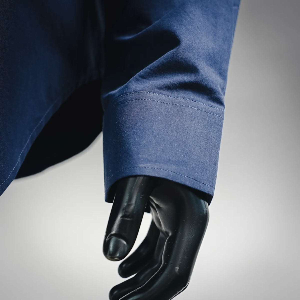 Blue long-sleeve shirt cuff with stitched hem and cuff opening.