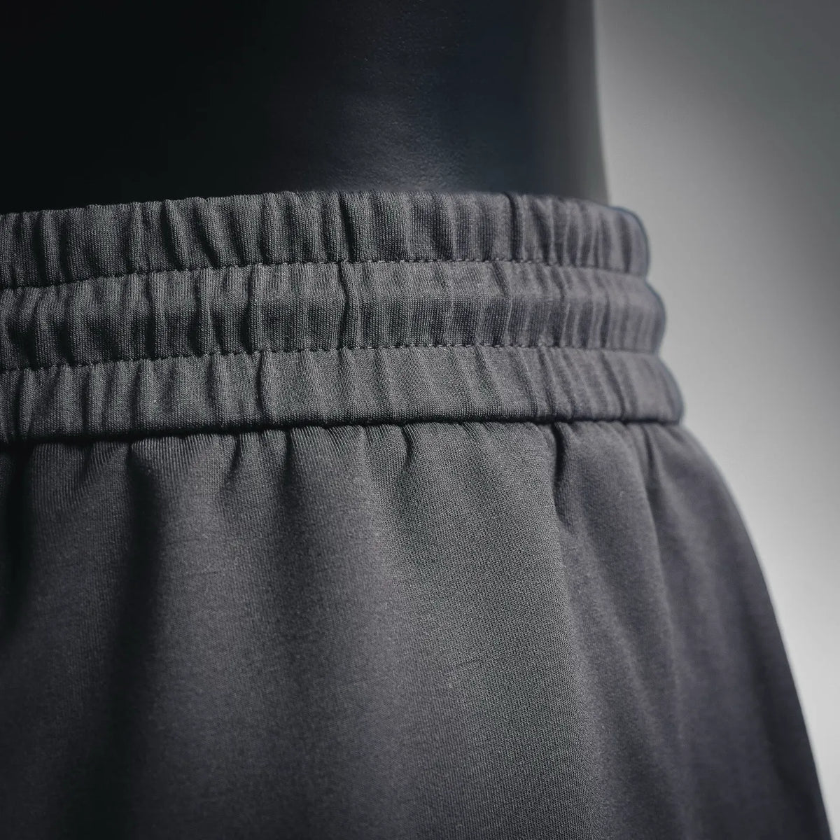 Black elastic waistband with gathered texture detail on shorts.