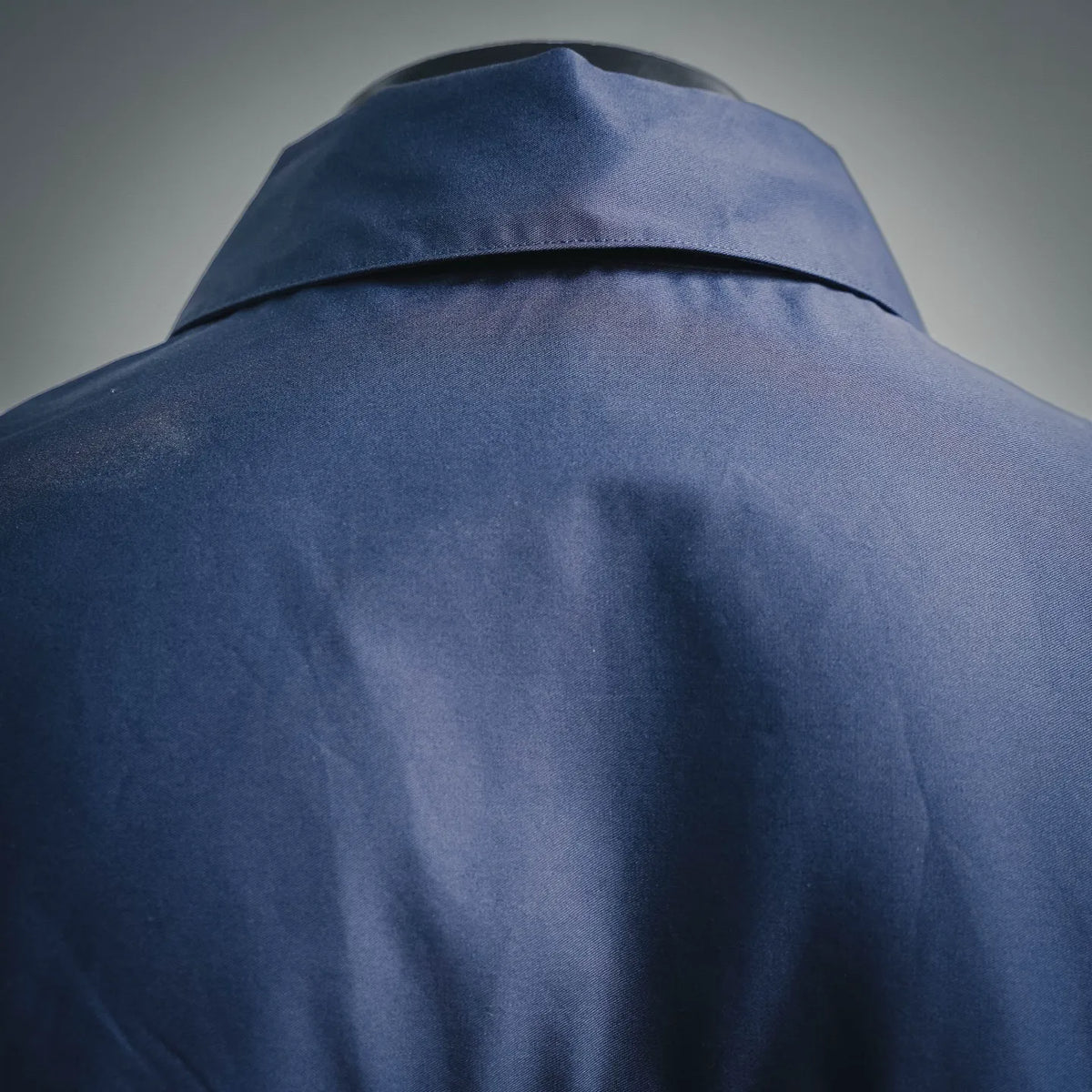 Blue long-sleeve shirt with stand collar and shoulder yoke seam close-up