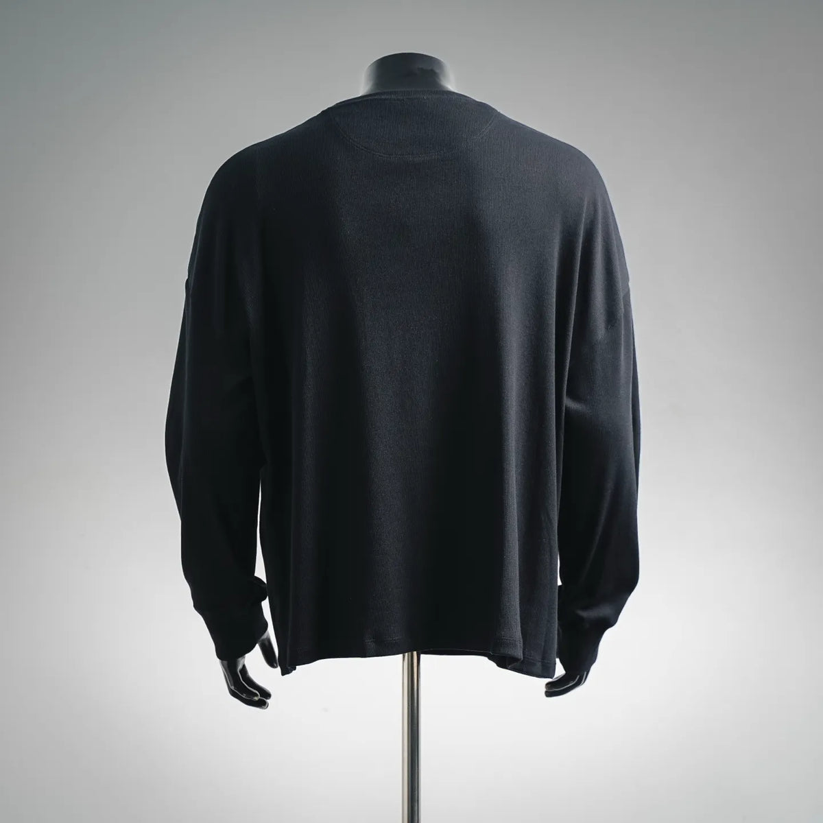 Dark LOEWE crewneck sweater on mannequin, back view with ribbed hem and cuffs
