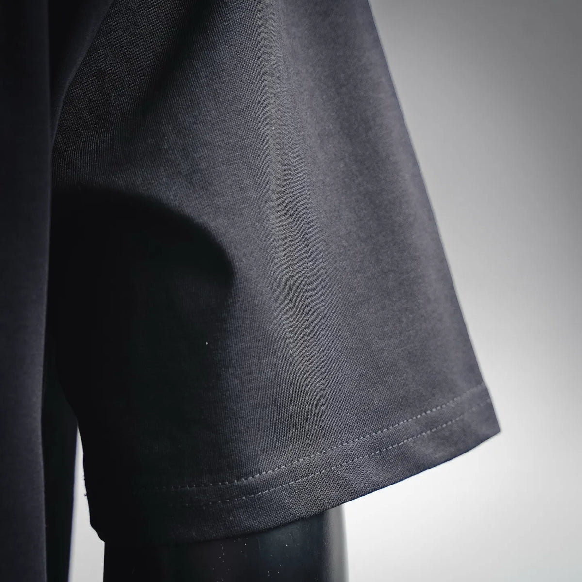 Black short-sleeve cuff with stitched hem detail and textured knit.