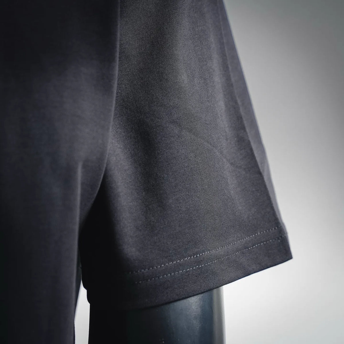 Black short-sleeve T-shirt with visible side seam and hem edge stitching.