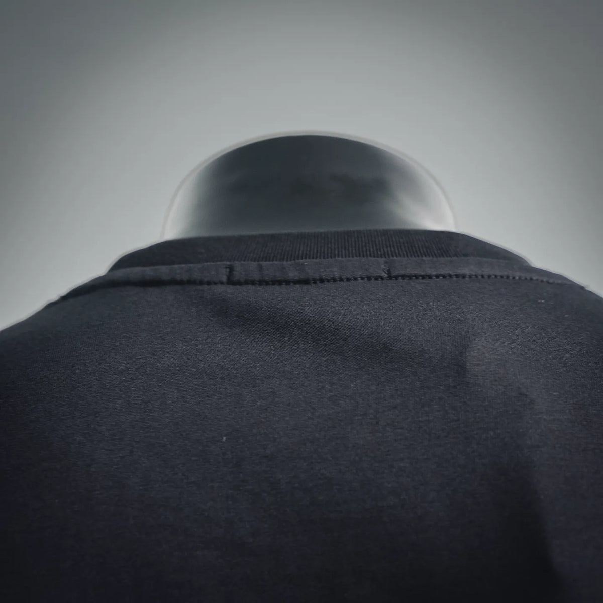 Black T-shirt neckline and shoulder seam detail on a mannequin.