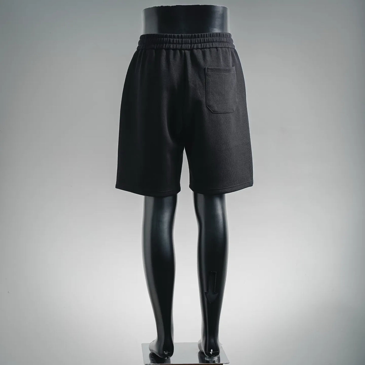 Black drawstring shorts on mannequin, side view with front pocket panel
