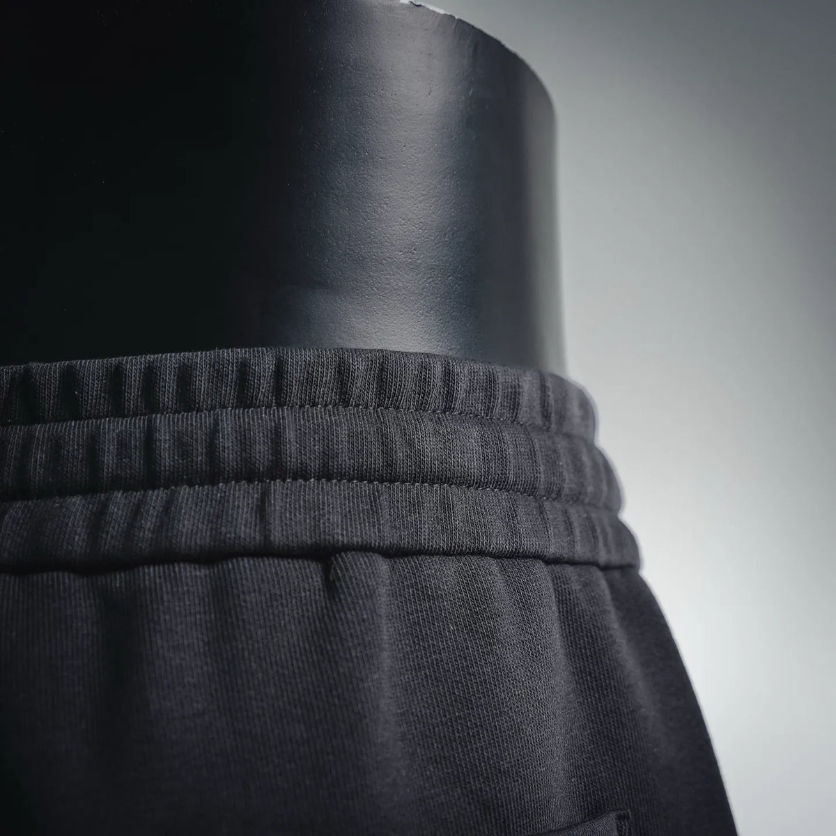 Black elastic waistband with gathered seams above shorts