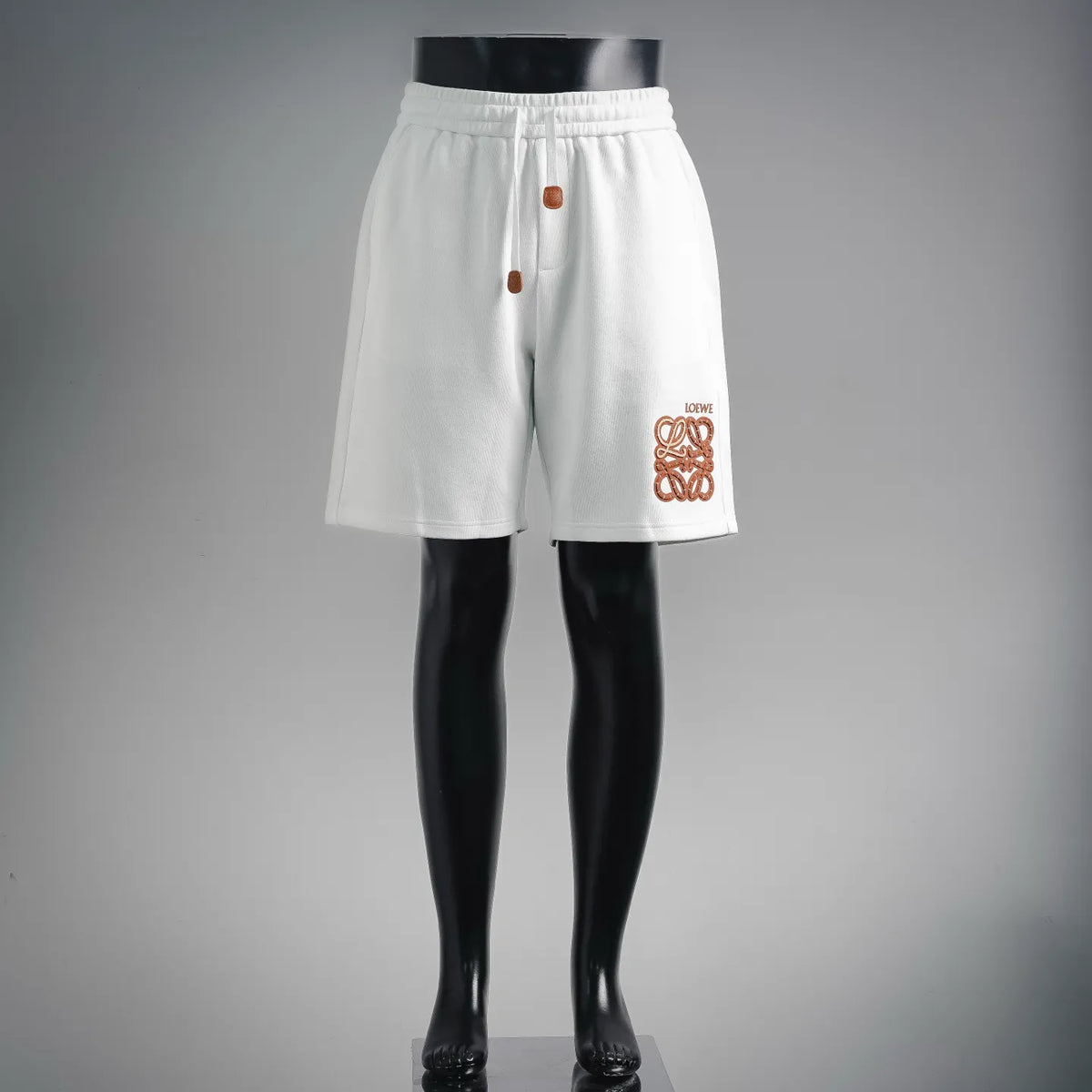 LOEWE white shorts with elastic waistband and orange logo patch on front hem