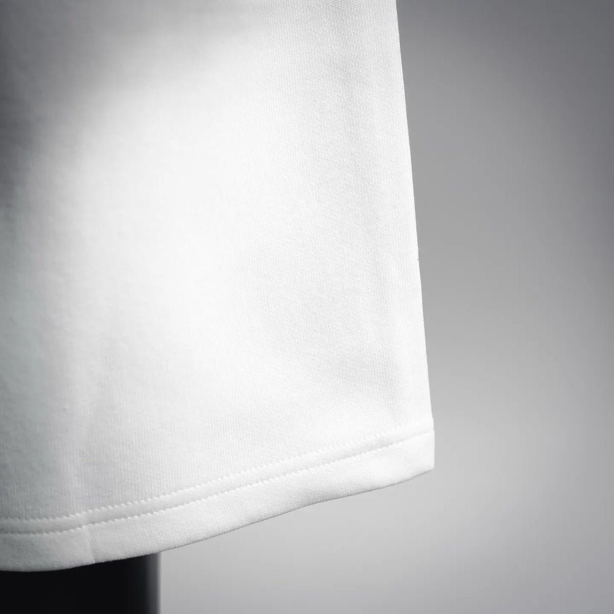 White shorts fabric close-up with clean hem and subtle texture