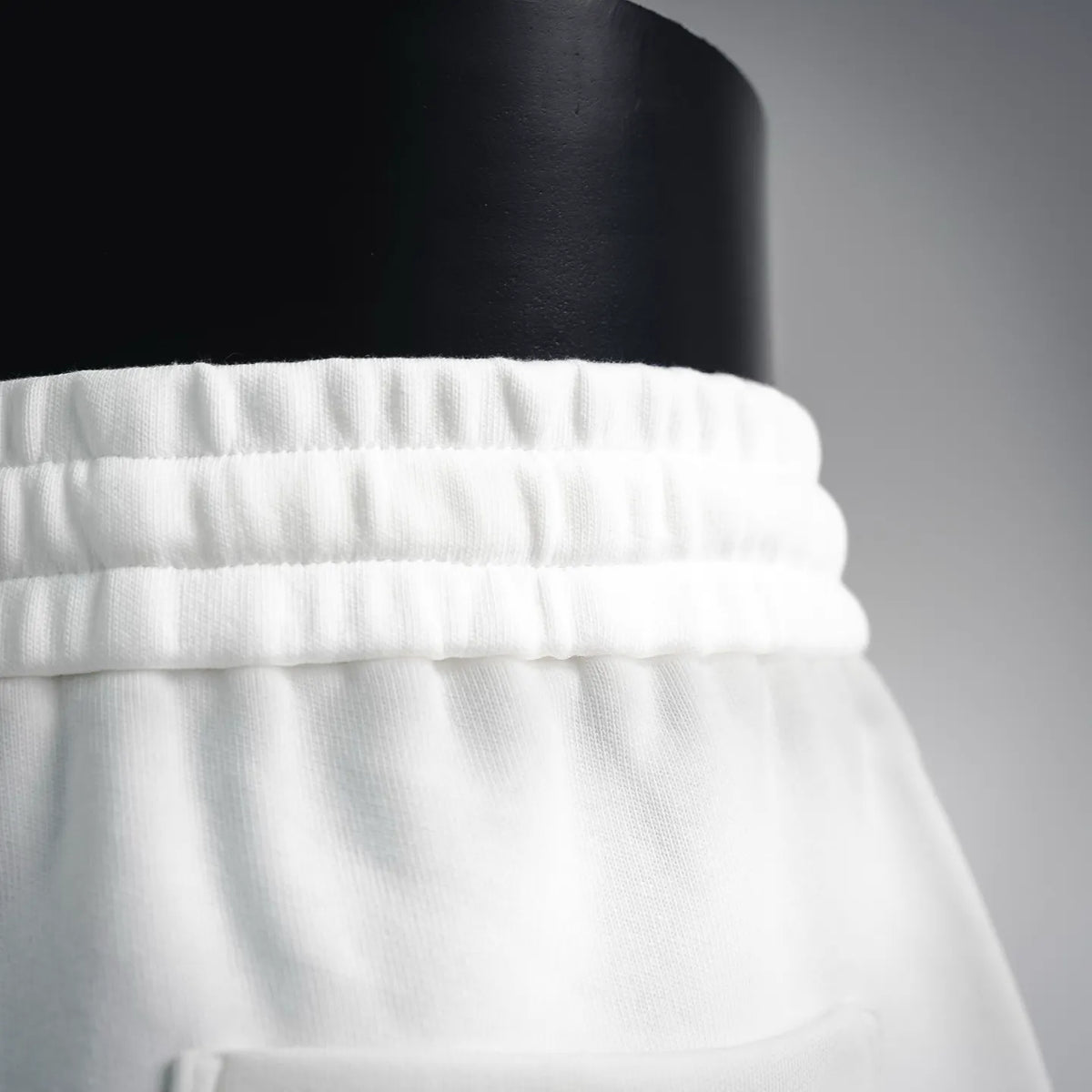 White shorts waistband close-up with gathered elastic and neat seams