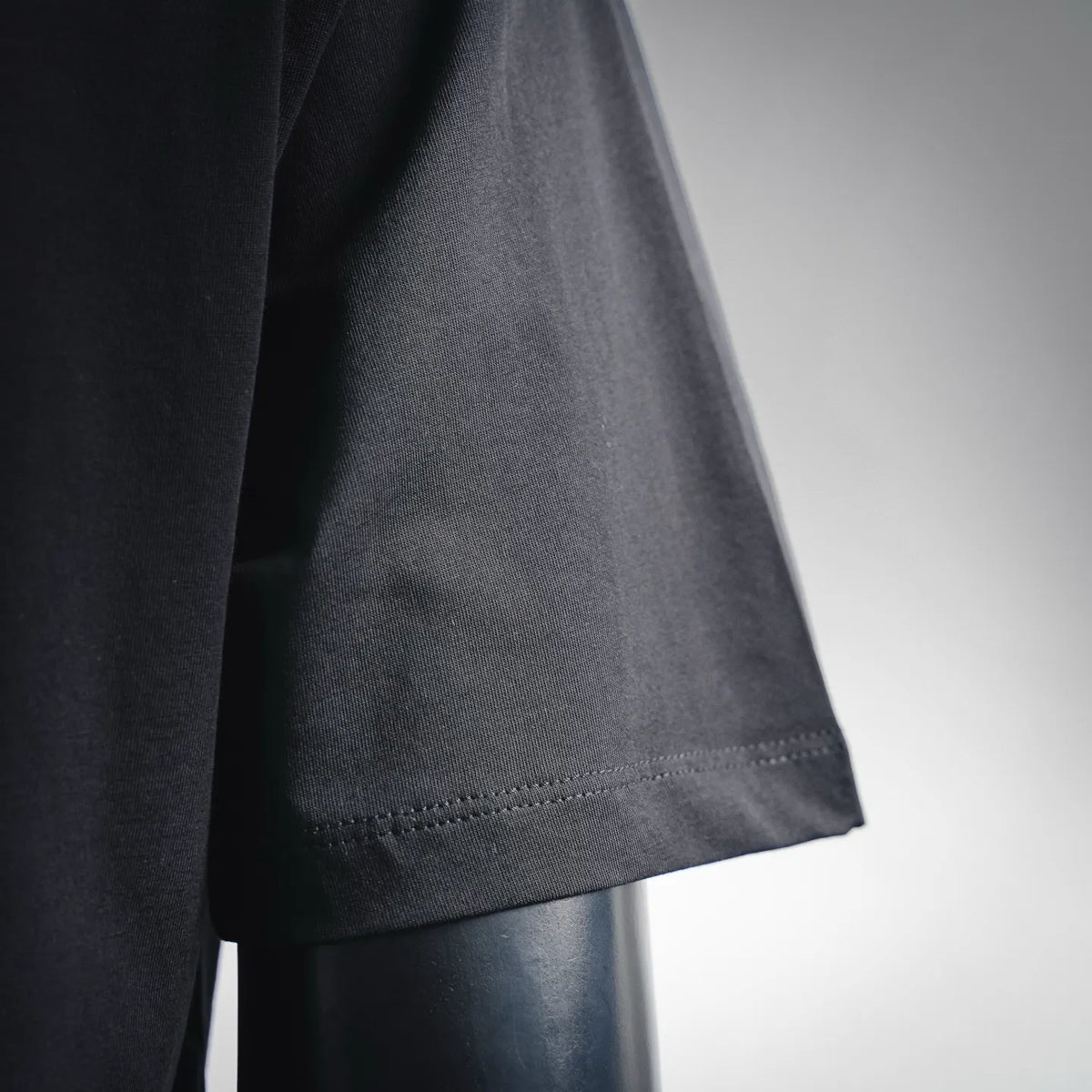 Black T-shirt sleeve hem with fine stitched edge