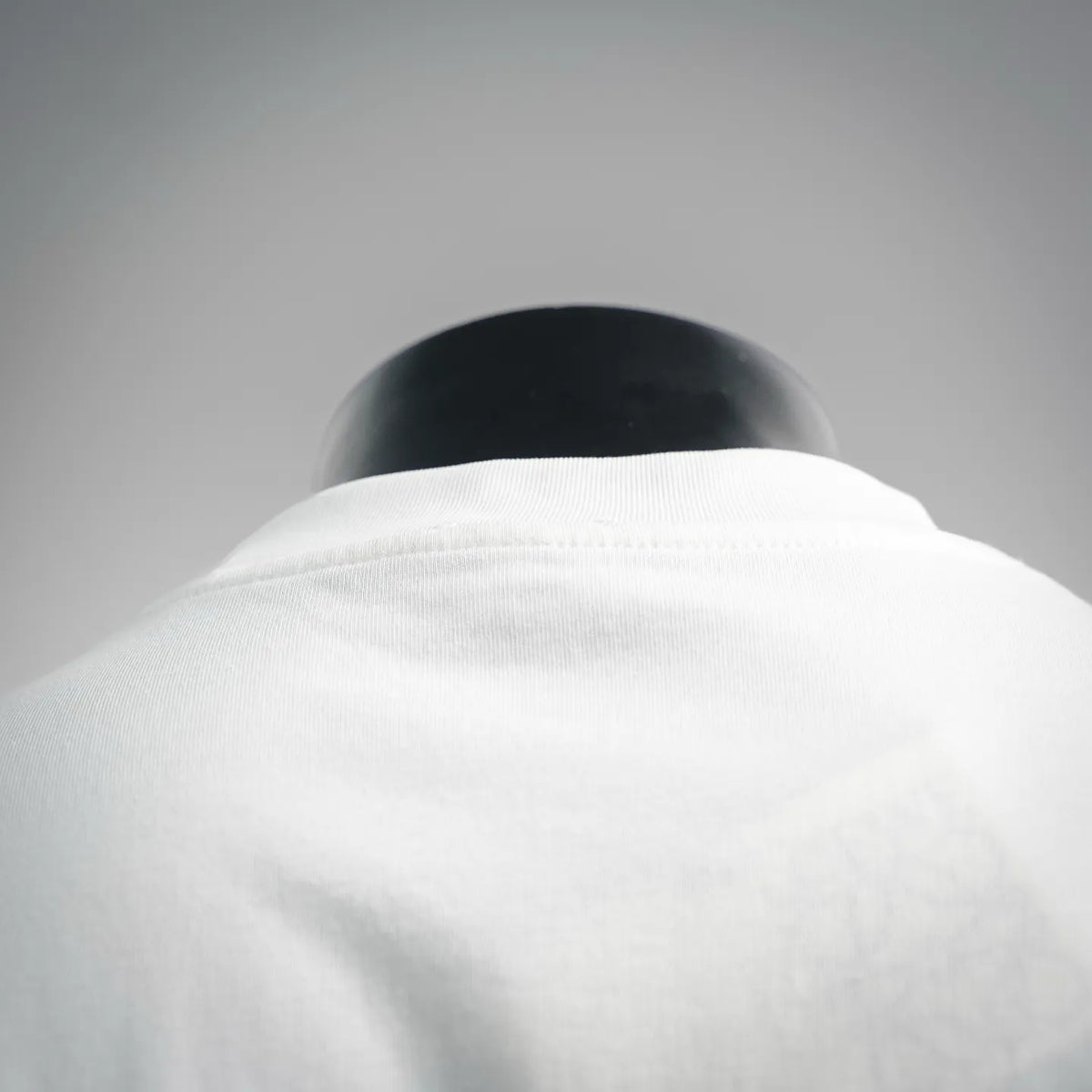 White T-shirt collar area on a mannequin, smooth crew neckline
