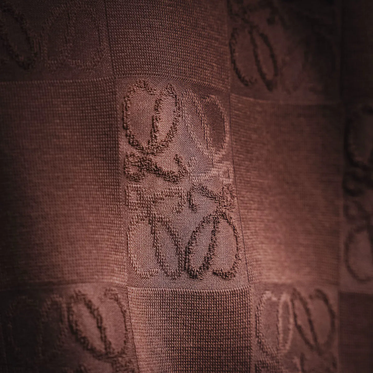 Taupe-brown T-shirt logo patch detail with embroidered-like square motif