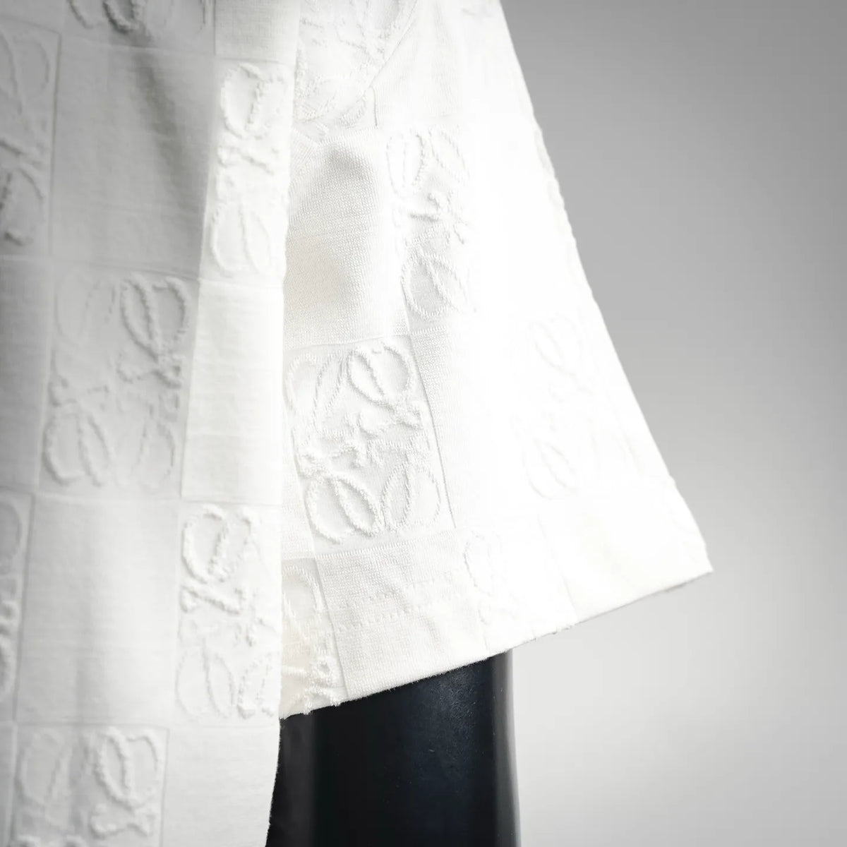 White short-sleeve shirt with raised pattern detail and curved hem