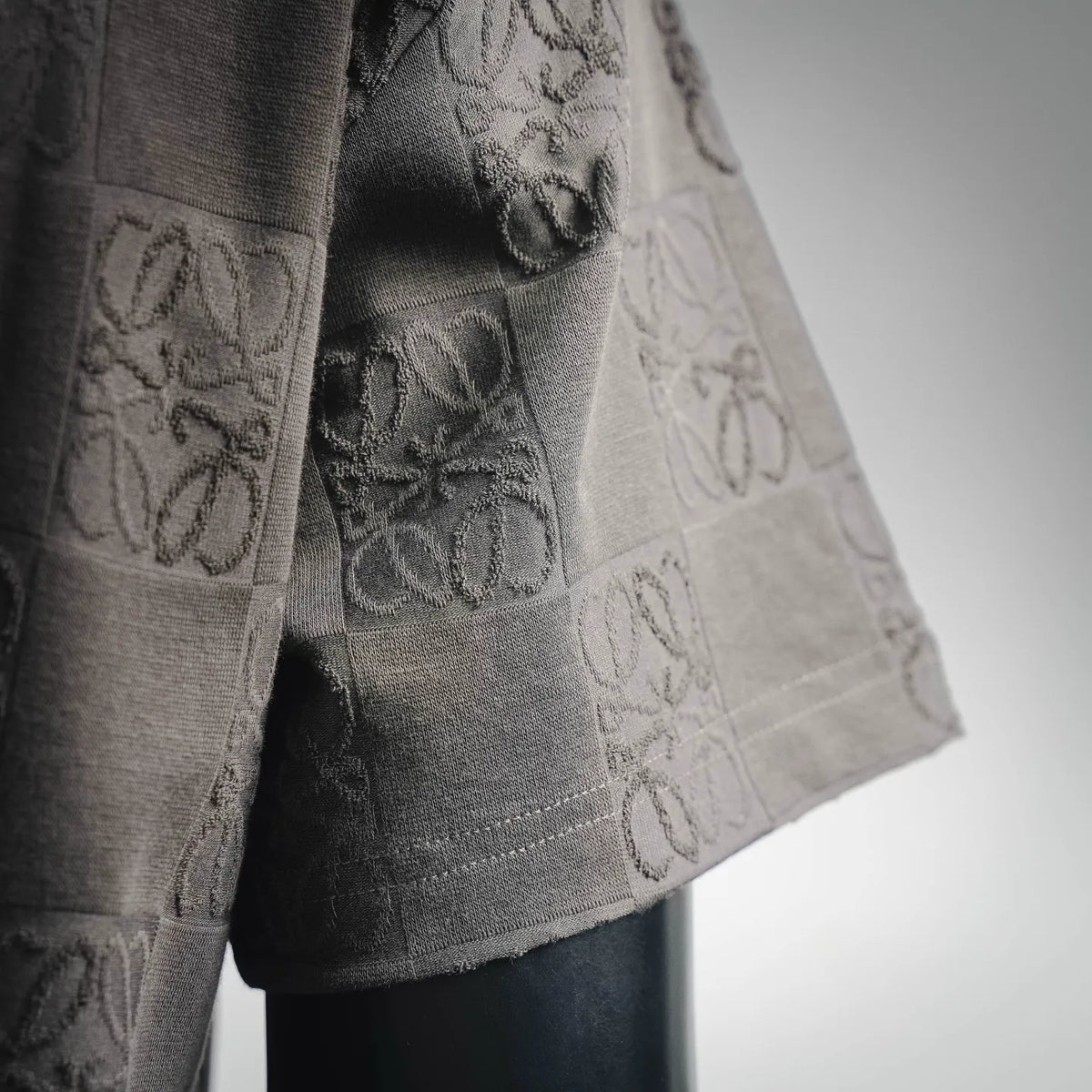 LOEWE T-shirt sleeve detail with embossed logo checkerboard texture in gray