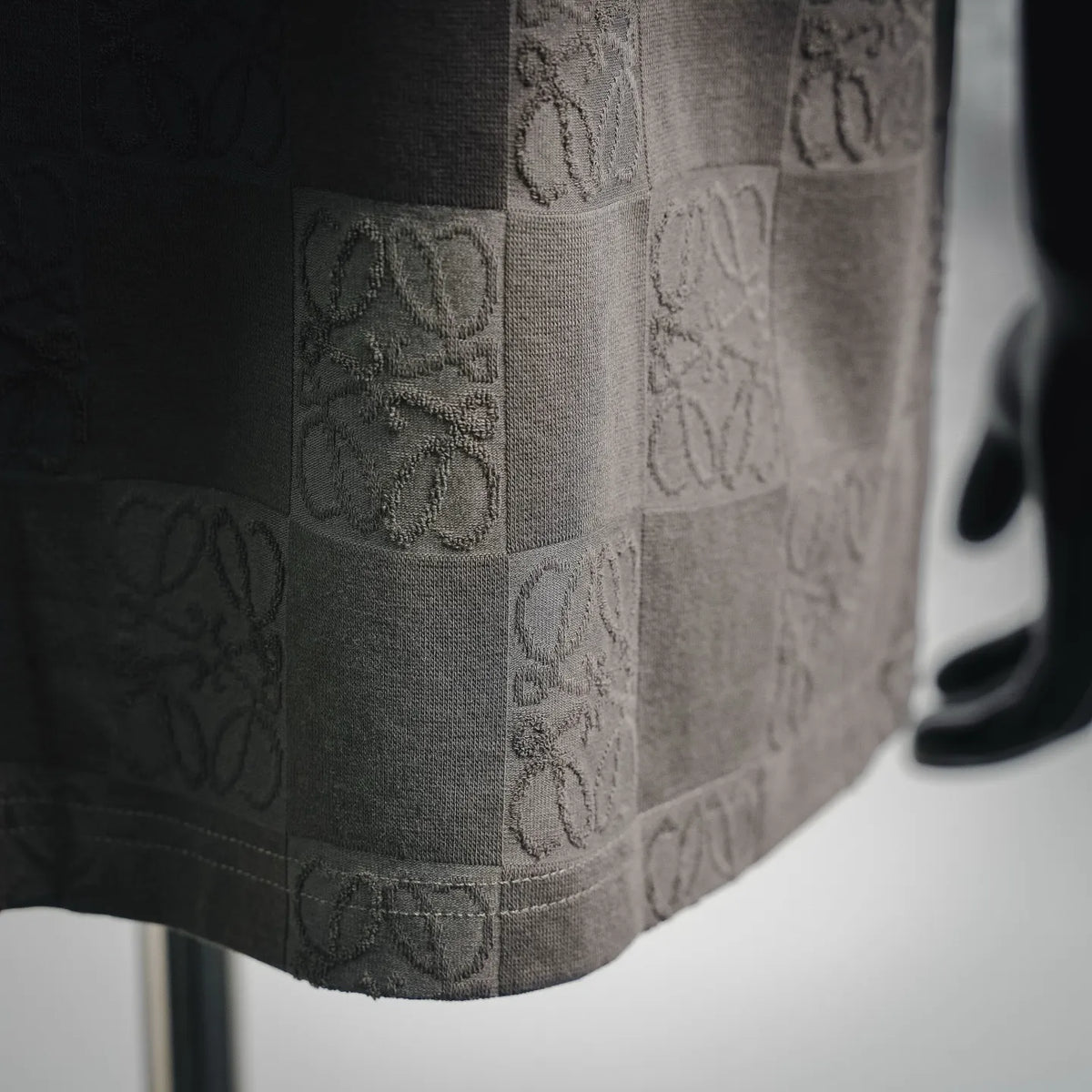LOEWE T-shirt hem and side view showing embossed logo checkerboard in gray