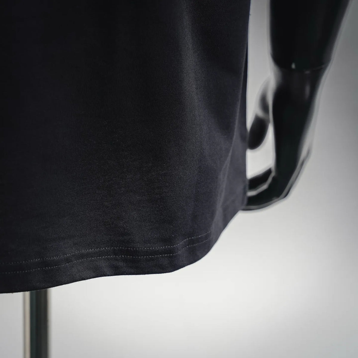 Black T-shirt hem close-up with visible stitching