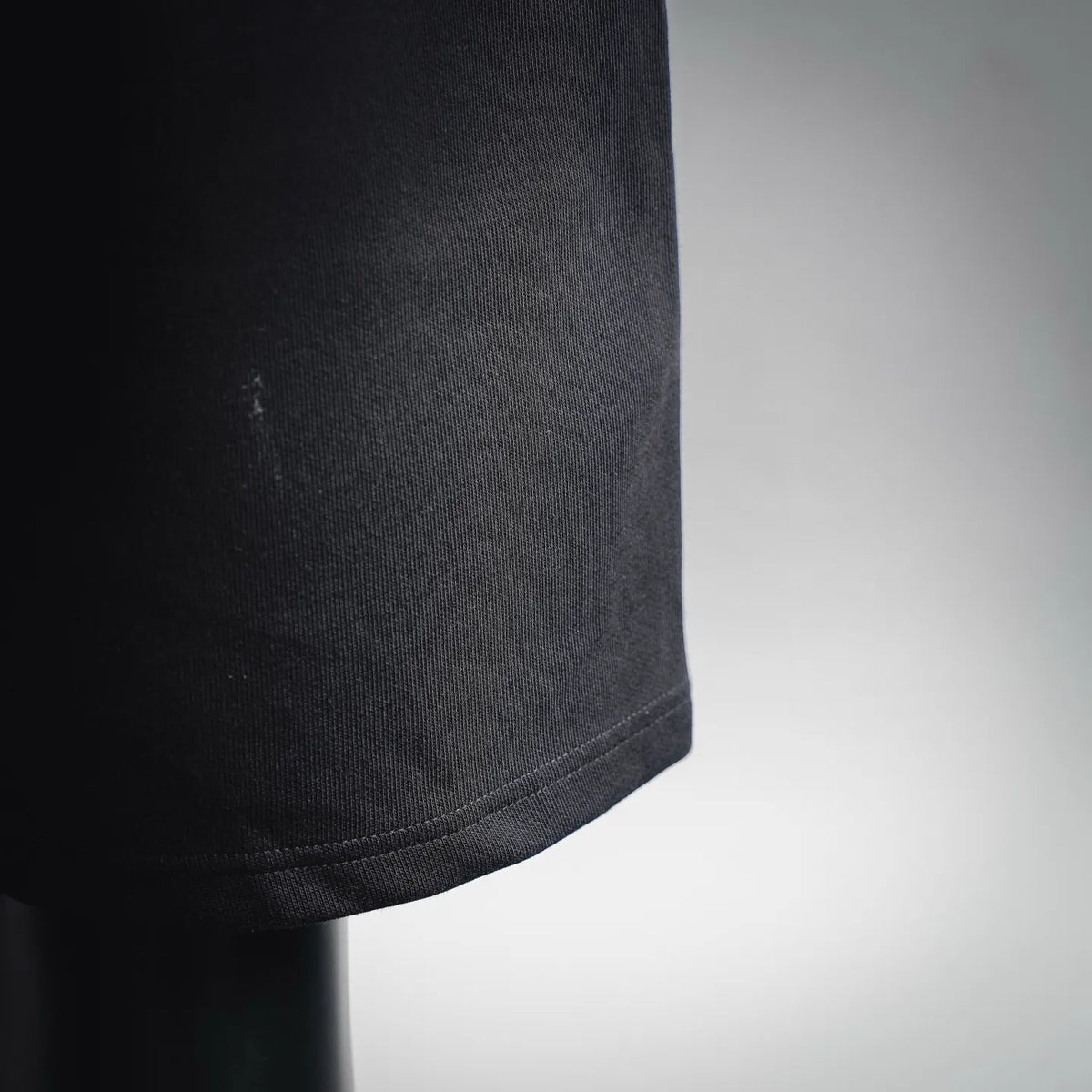 Black knit fabric close-up with visible texture and side seam