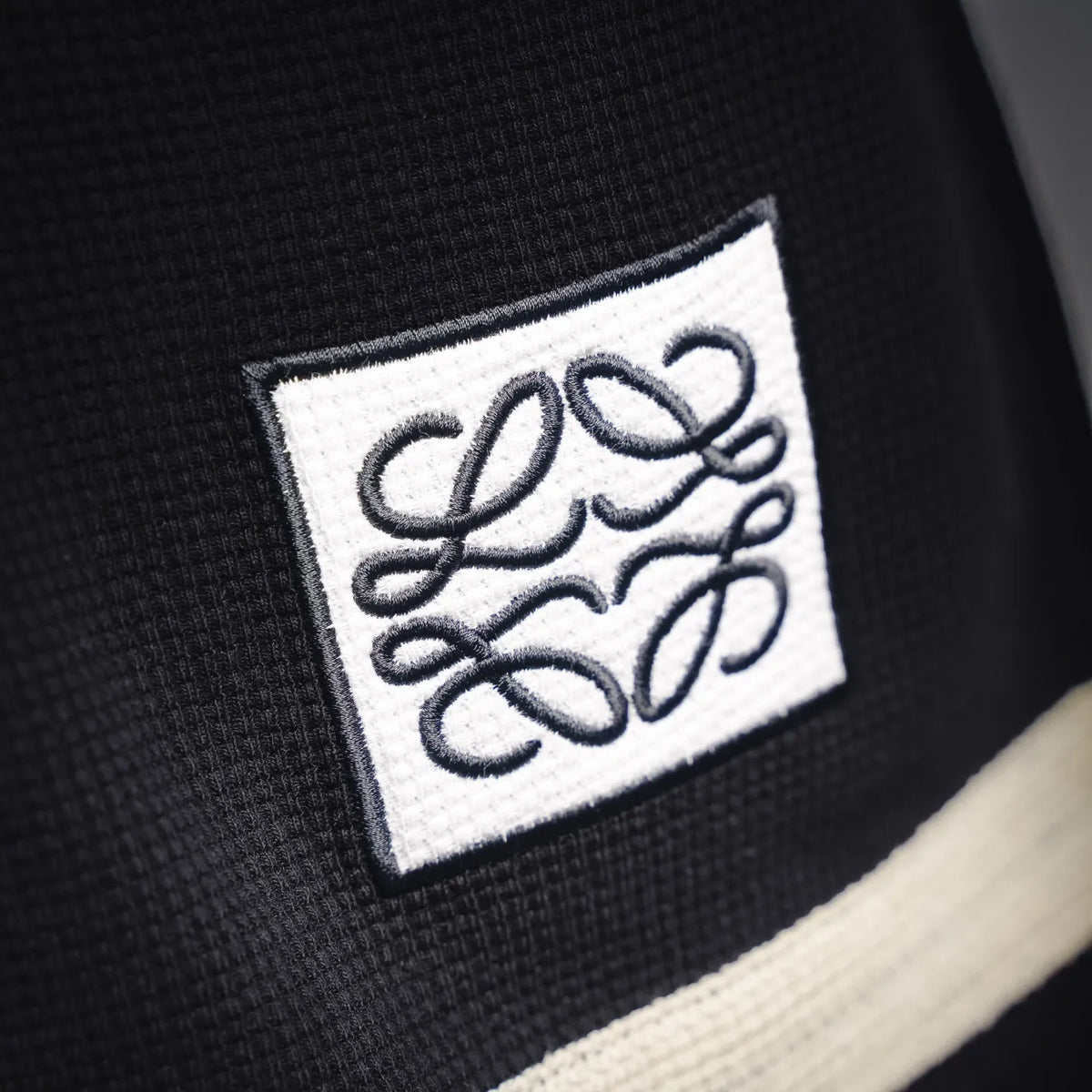 LOEWE logo patch on black knit top with cream stripe