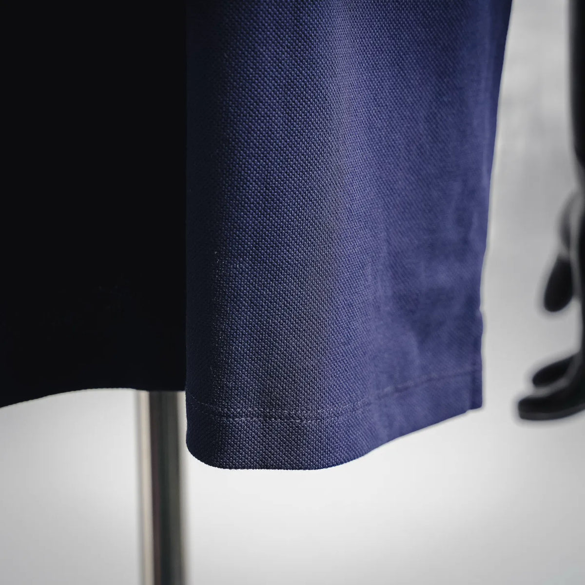 Dark blue polo shirt hem with fine textured fabric