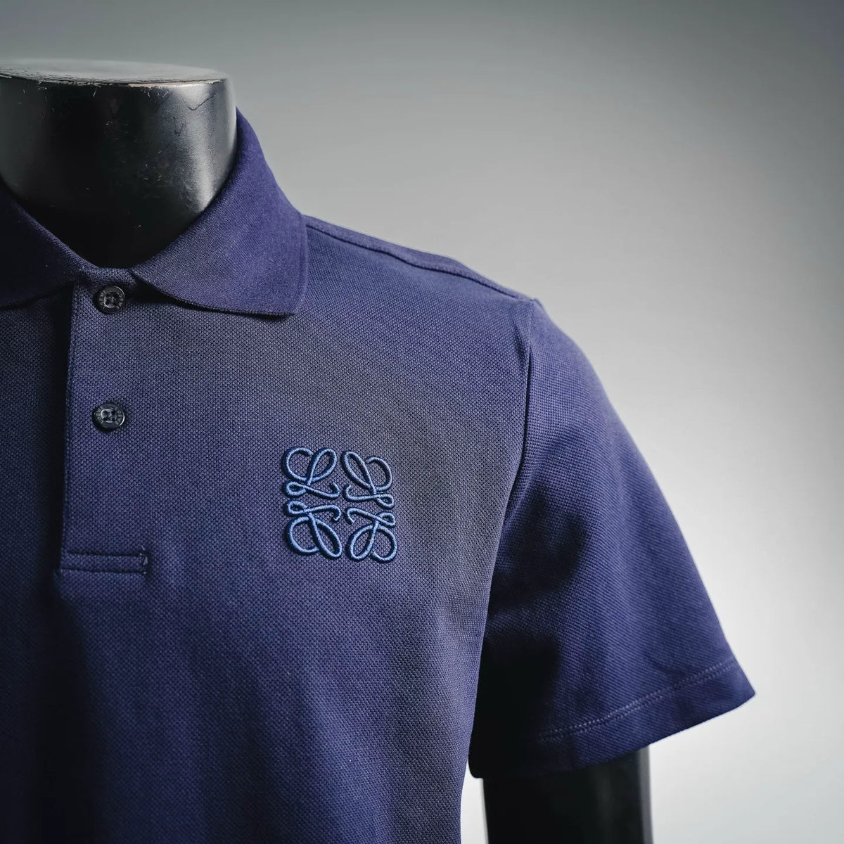 Dark blue short-sleeve polo shirt with embroidered emblem on chest