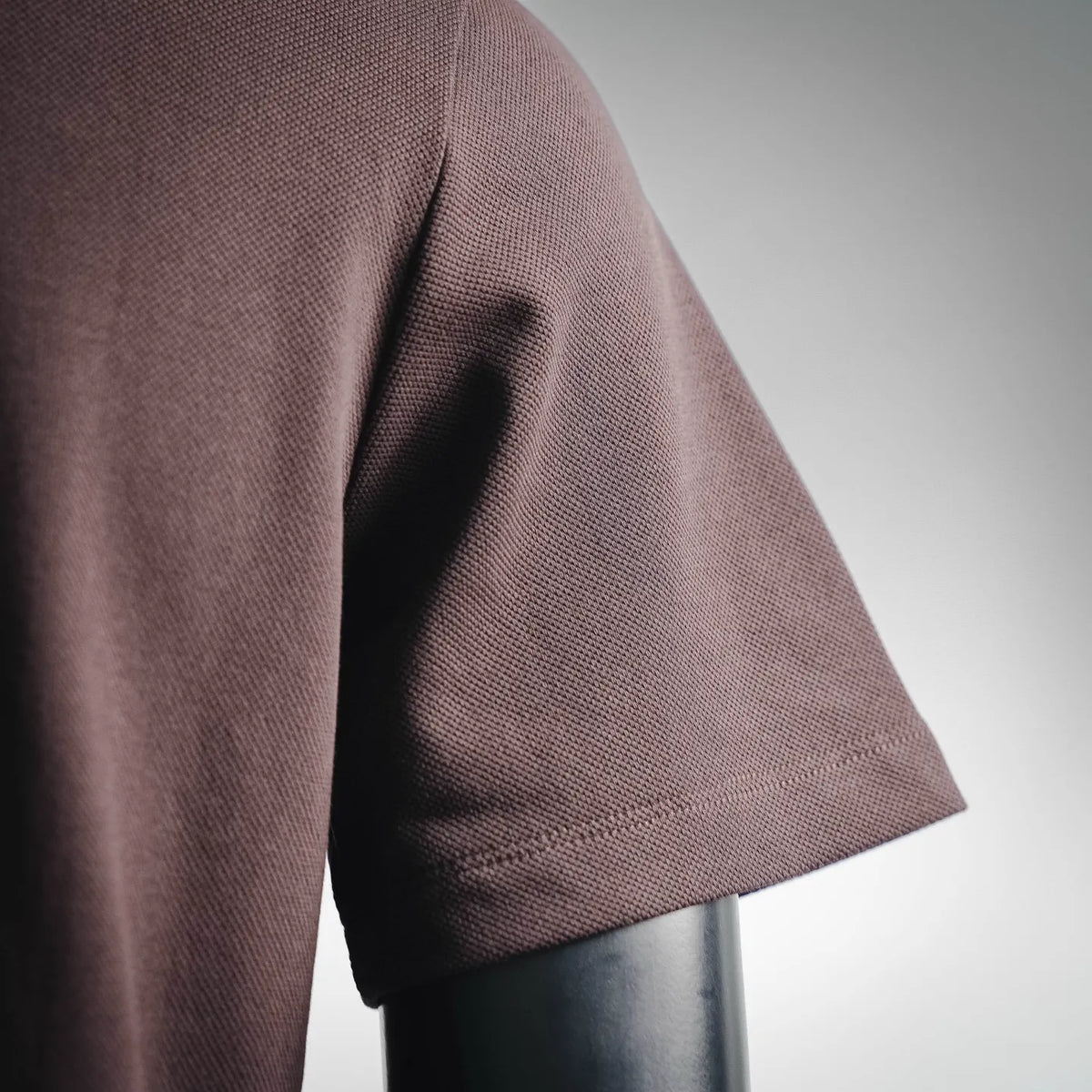 LOEWE dark plum polo shirt sleeve with stitched hem and textured fabric