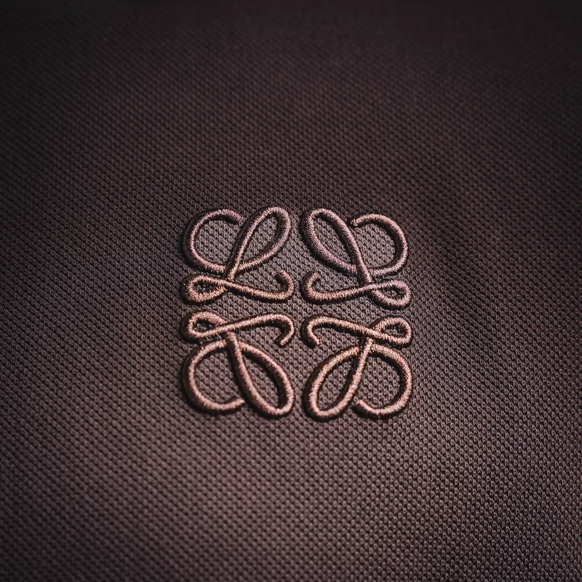 Embroidered LOEWE-style logo on dark plum polo shirt chest