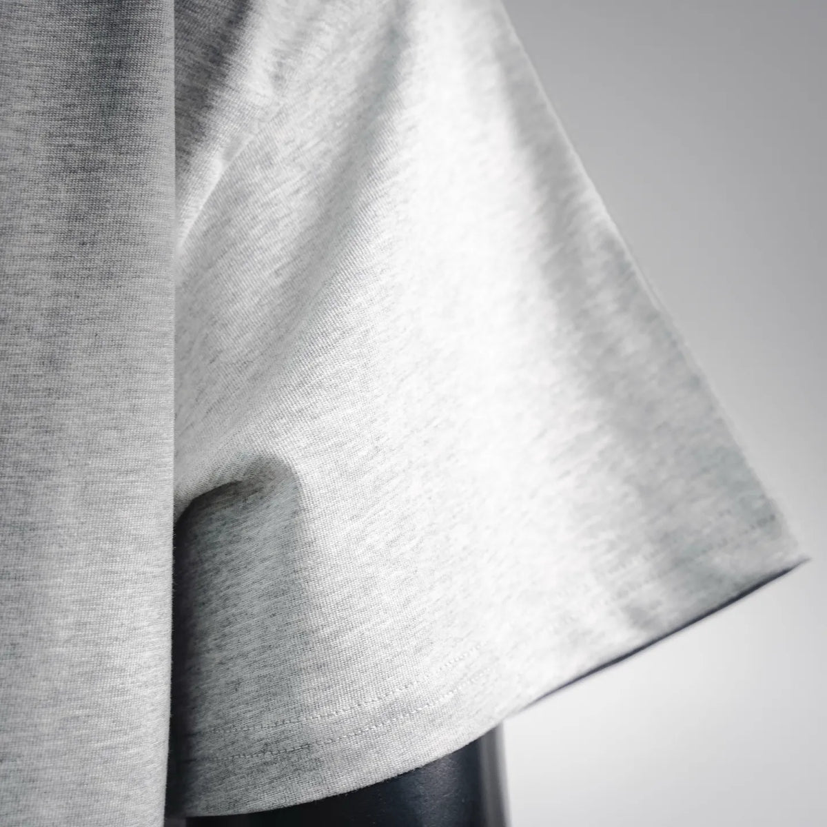 Grey short-sleeve T-shirt sleeve and curved hem close-up