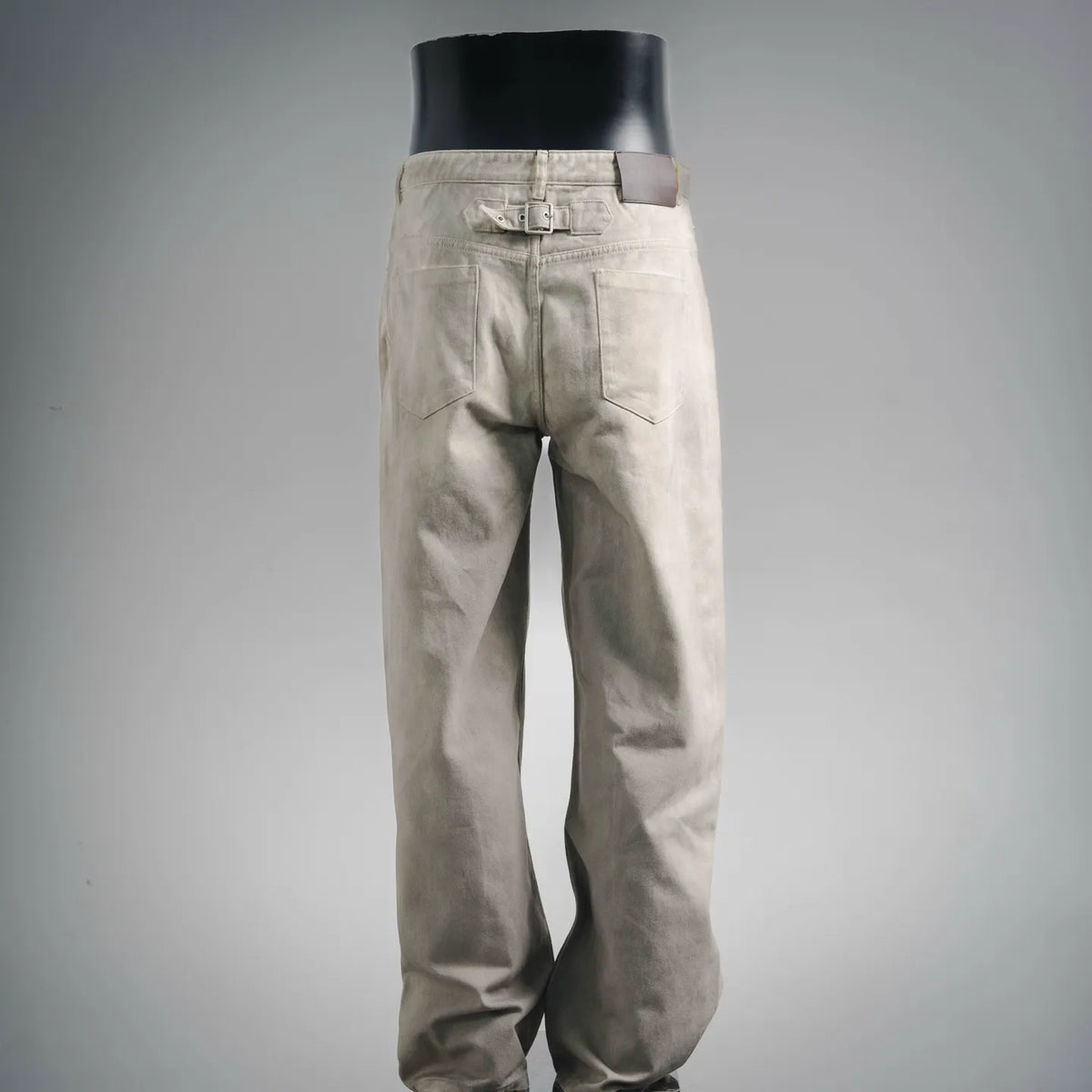 Beige pants with front pockets, button fly, and straight-leg silhouette