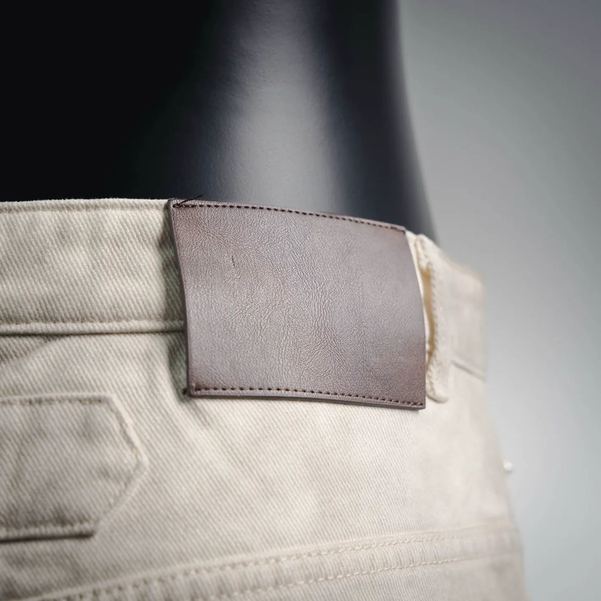 Beige pants with coin pocket and stitched leather-look label patch