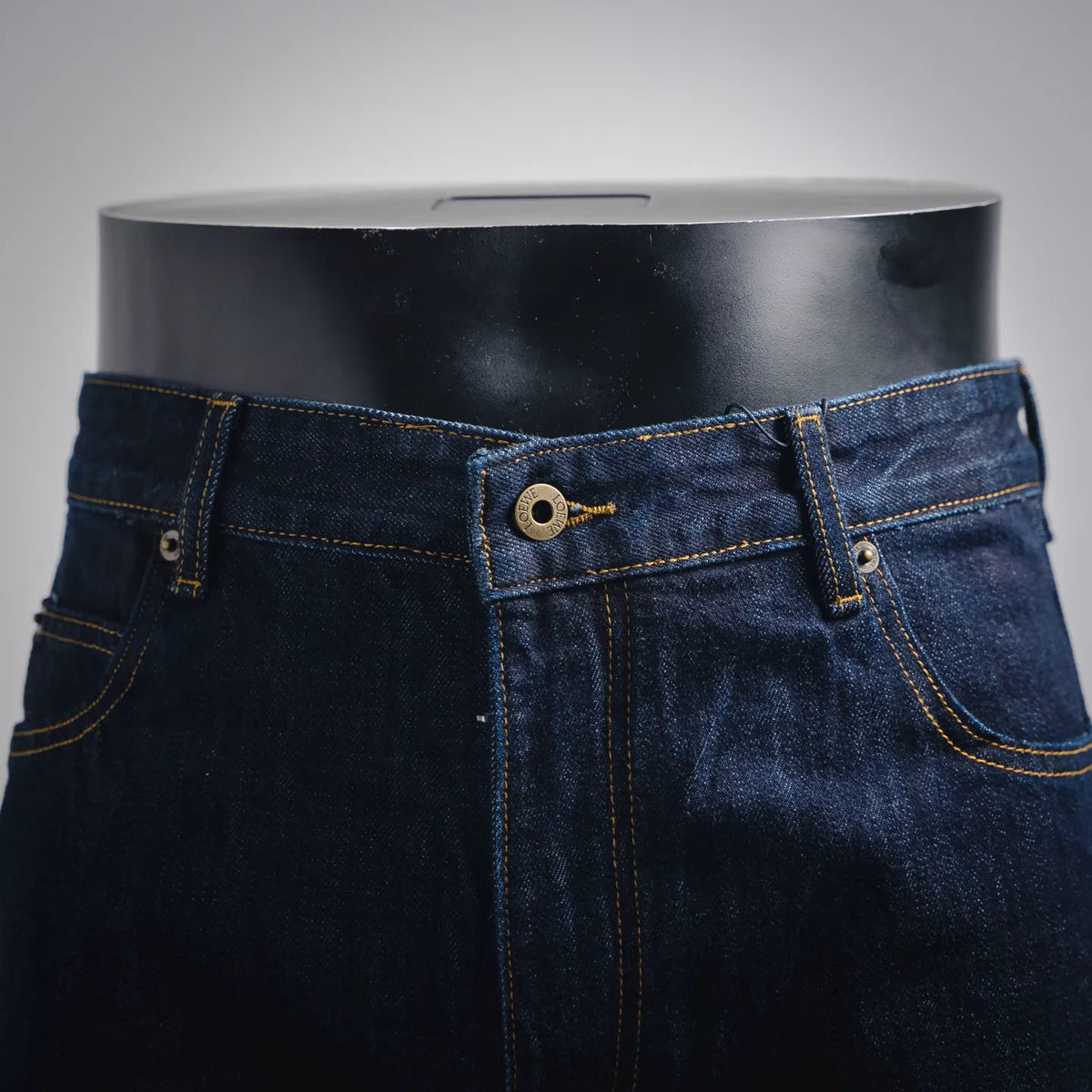 Dark blue denim pants with front button fly and belt loops