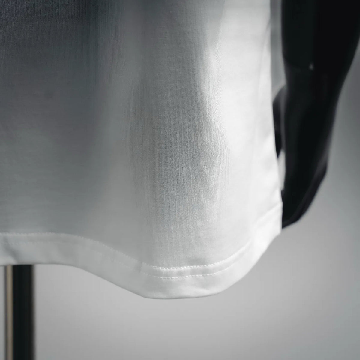 White T-shirt front hem with stitched neckline and curved bottom edge