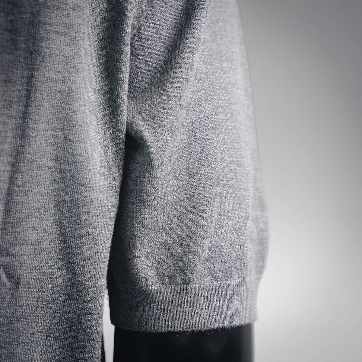 Gray knit top with ribbed hem and side hem close-up