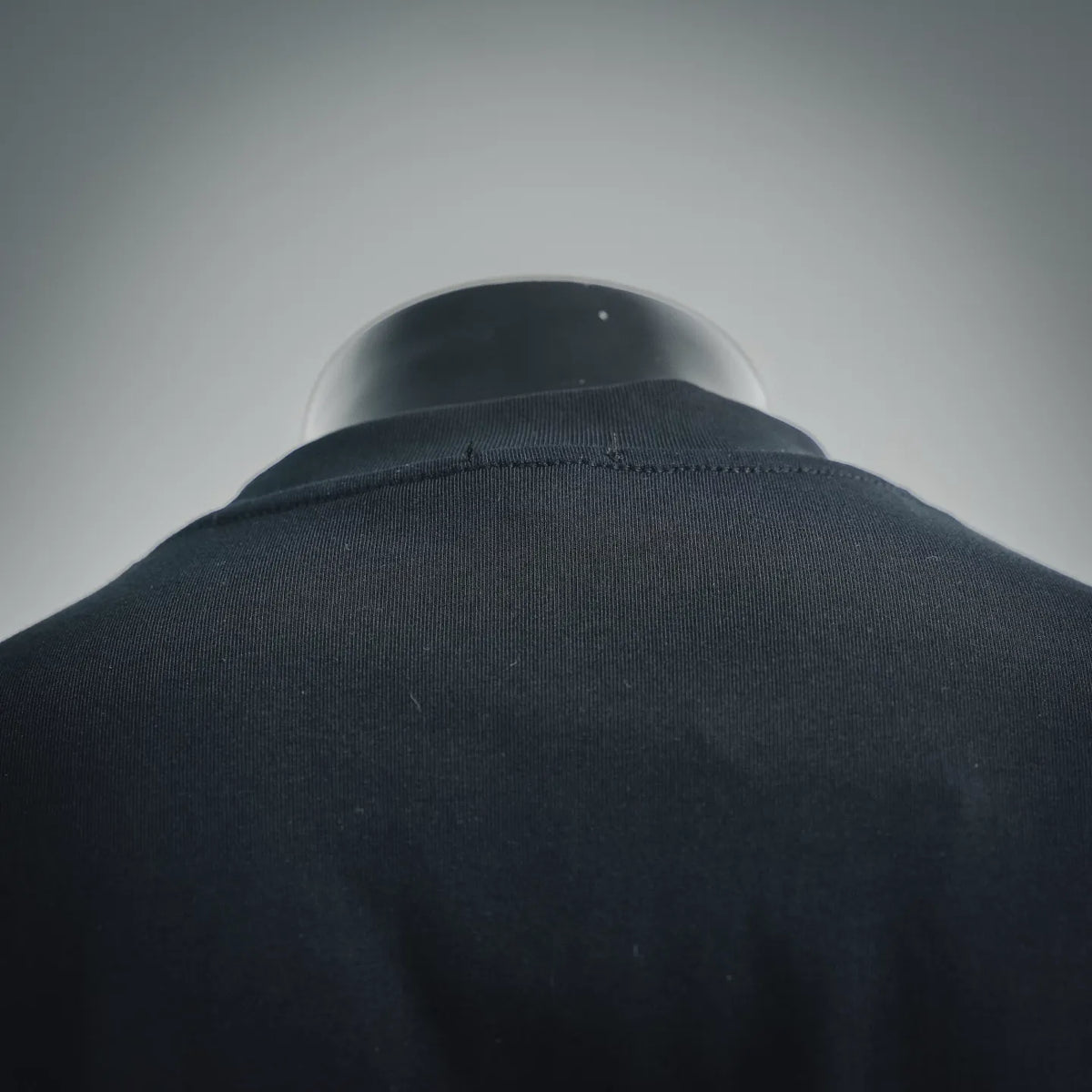 Black T-shirt crew neckline and collar ribbing, close-up.