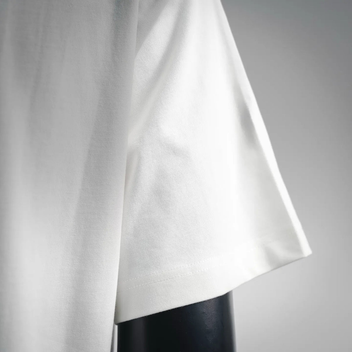 White short-sleeve T-shirt with stitched hem and drape on mannequin