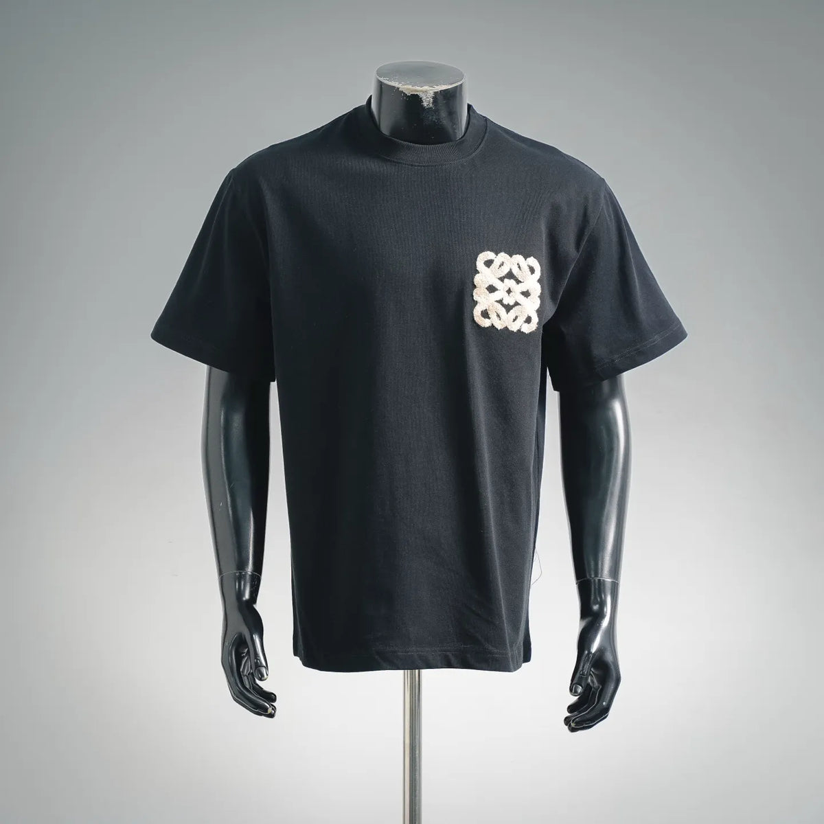 Black crewneck short-sleeve T-shirt with cream embroidered logo on chest