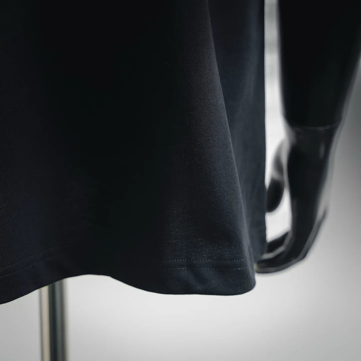Black crewneck T-shirt close-up of fabric texture and curved hem