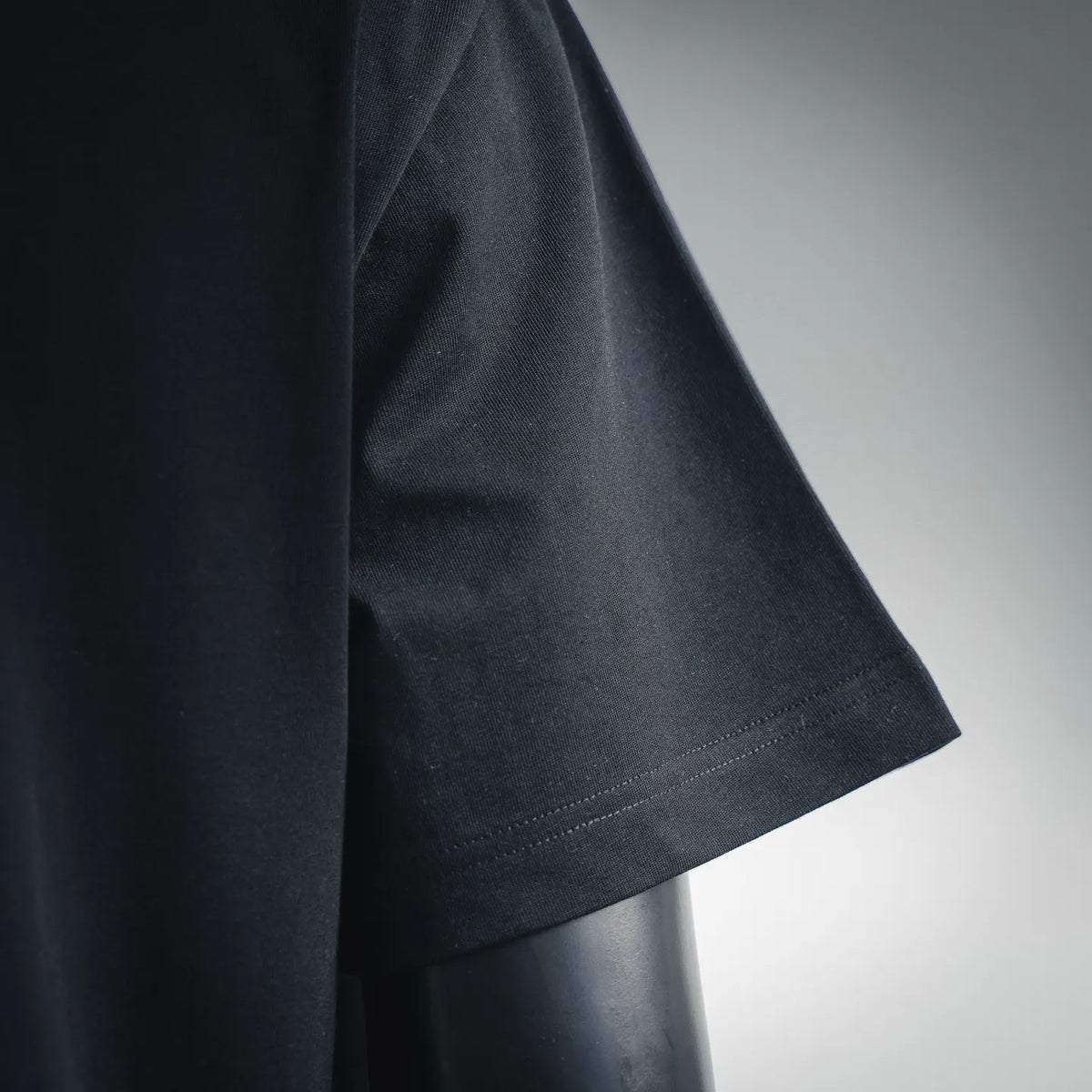 Black short-sleeve T-shirt close-up of sleeve and stitched hem