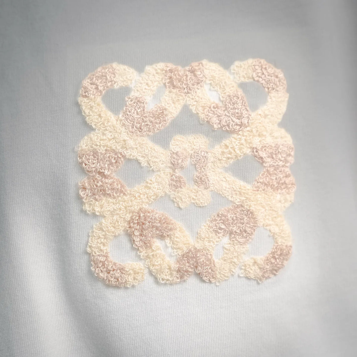 White short-sleeve T-shirt with large beige textured logo patch