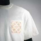 White short-sleeve T-shirt with beige textured logo patch on chest