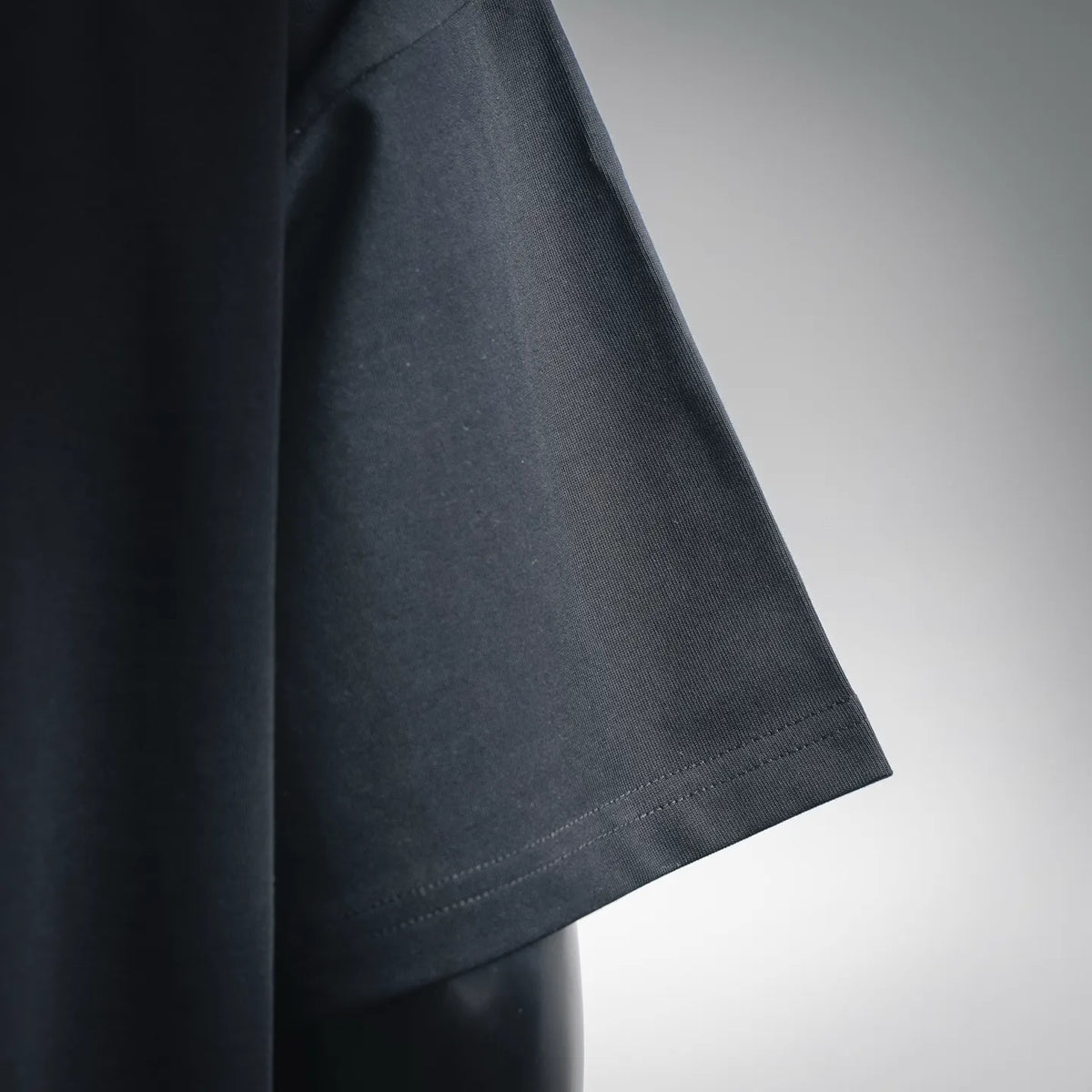 Black short-sleeve T-shirt sleeve close-up with straight hem stitching