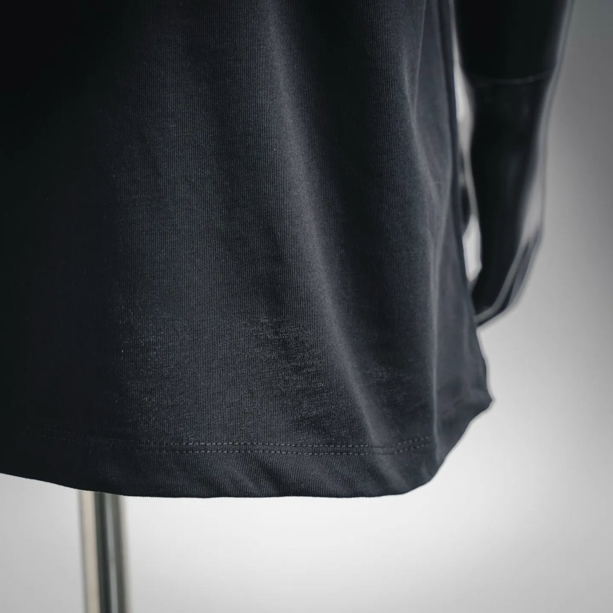 Black crewneck T-shirt lower side hem with visible stitching