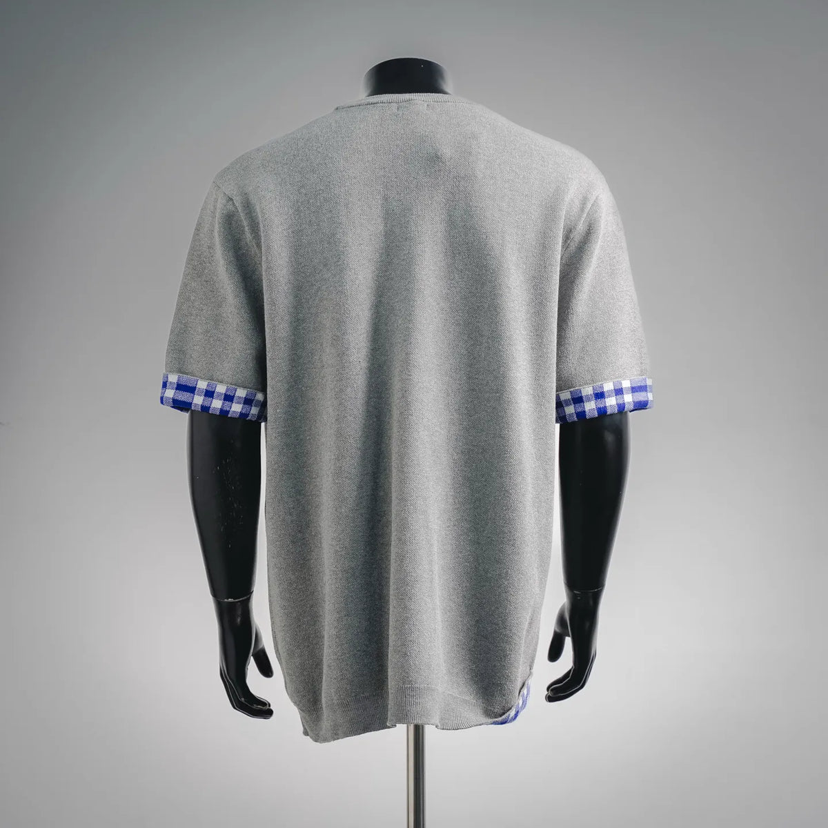Grey crewneck short-sleeve shirt on mannequin with blue checkered cuff trim