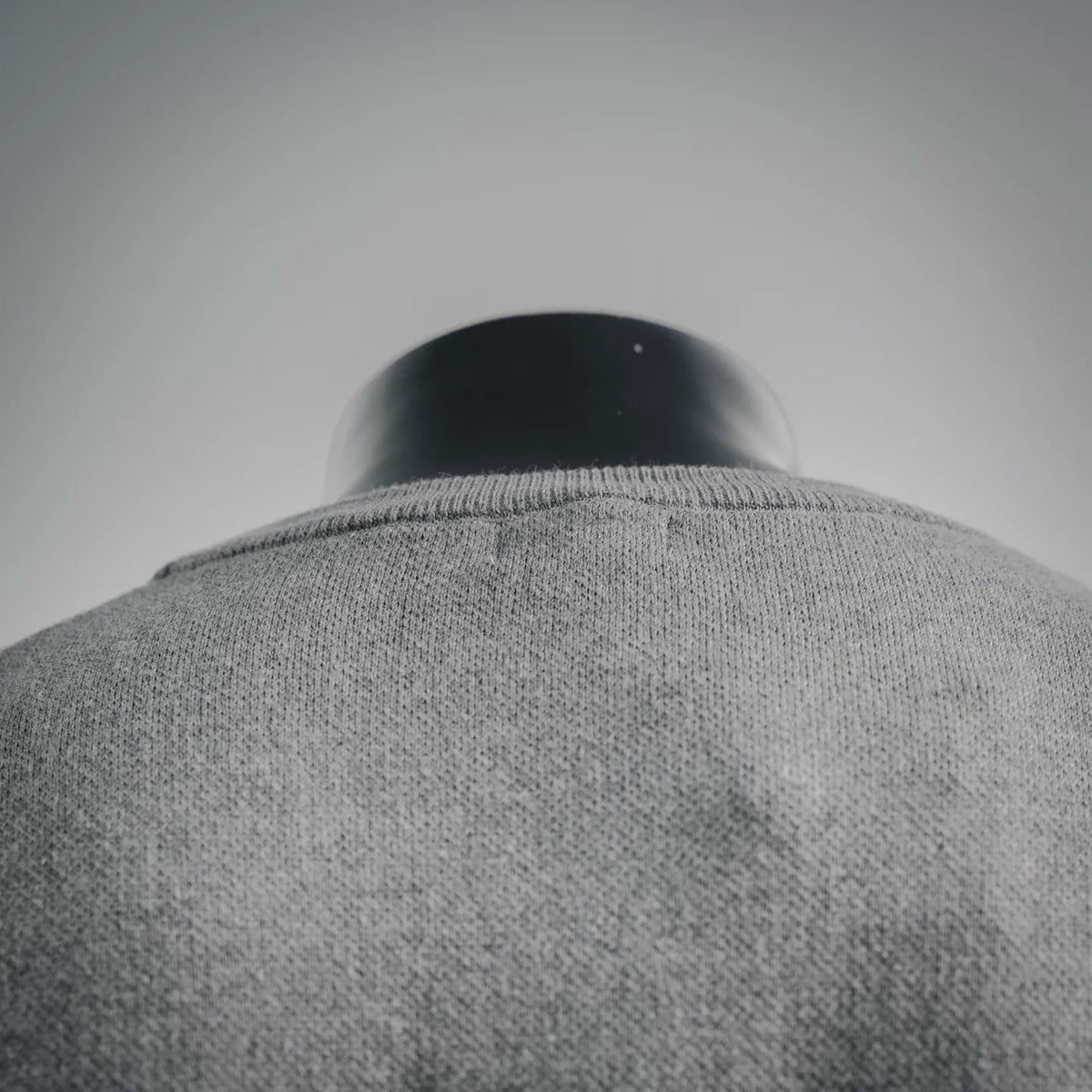 Grey crewneck collar with ribbed knit trim on the back of the shirt