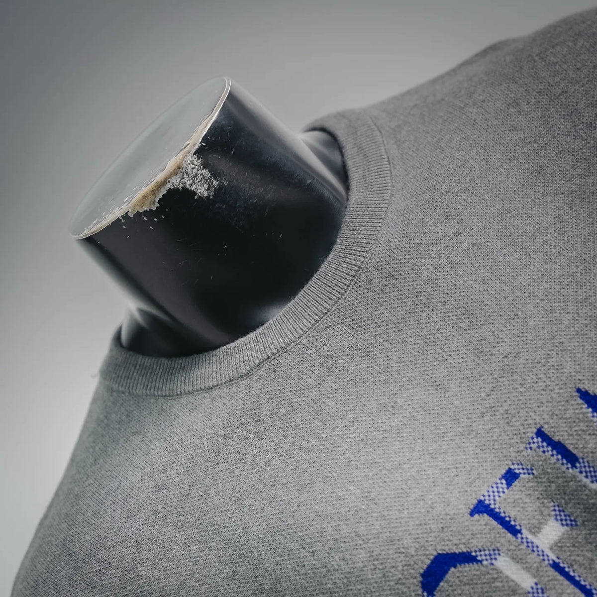 Grey crewneck collar with small blue LOEWE logo detail on chest
