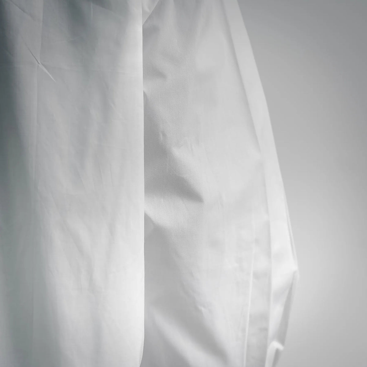 Close-up of white dress shirt front panel with vertical seams