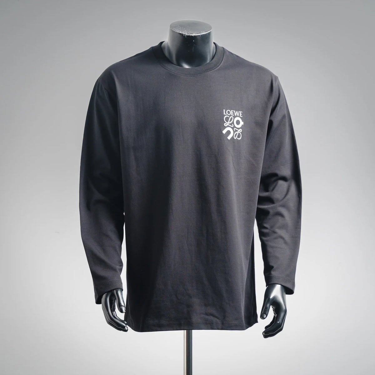 Dark LOEWE long-sleeve crewneck shirt on mannequin, small chest logo