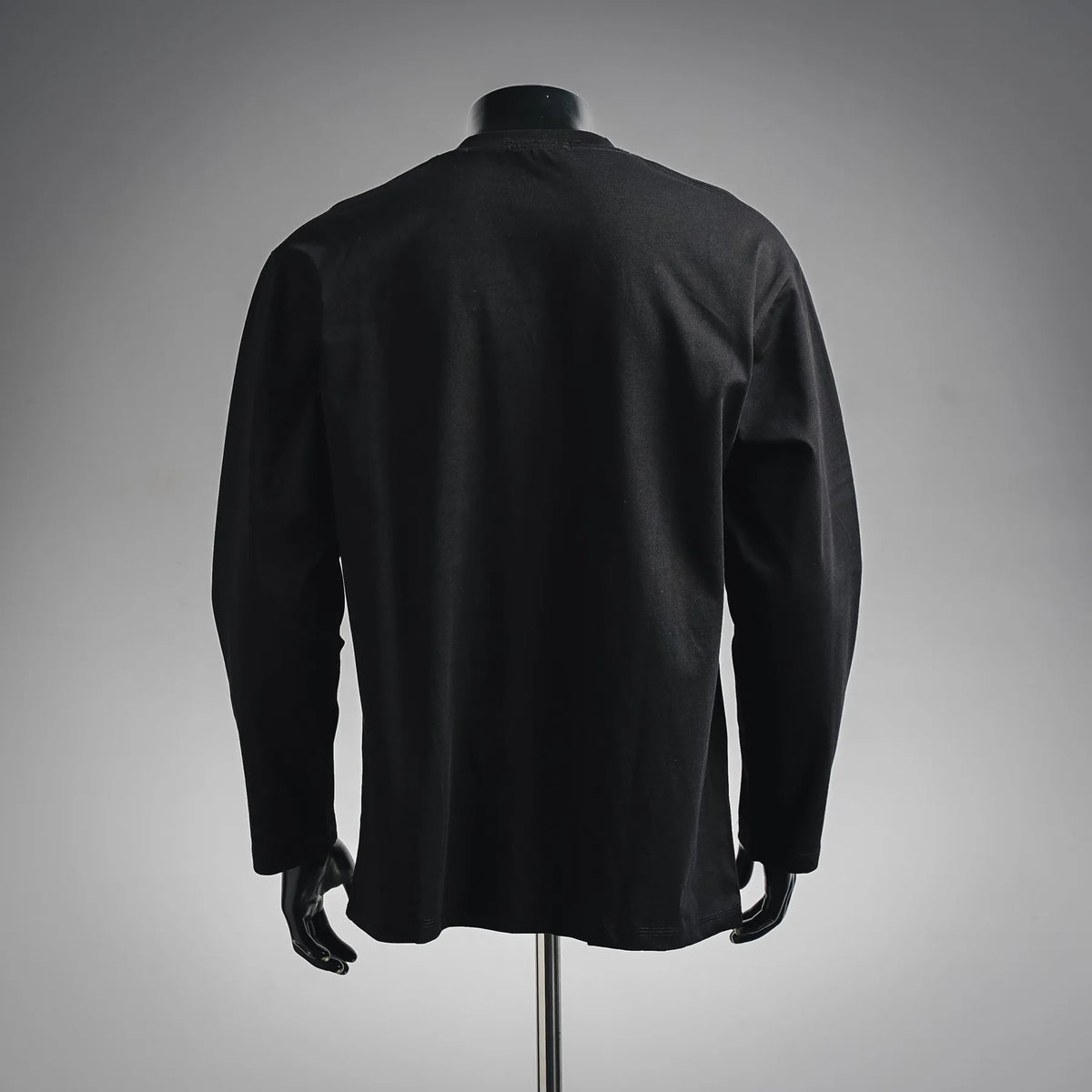 Black long-sleeve crewneck shirt on a mannequin, back view