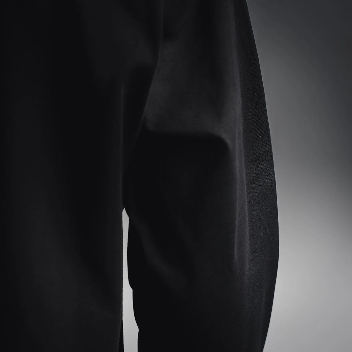 Black long-sleeve shirt fabric close-up on the torso