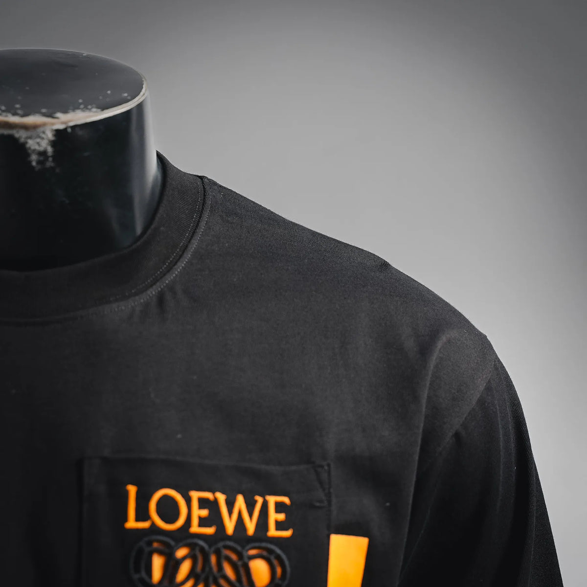 Black shirt chest logo patch with LOEWE text in orange